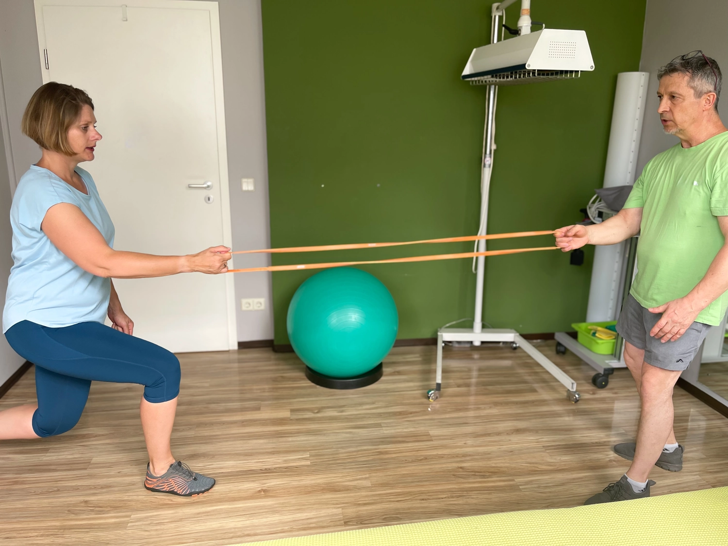 Fitnesstrainer und Berater - Wolfgang Bzdok trainiert eine Frau mit einem Gummiband